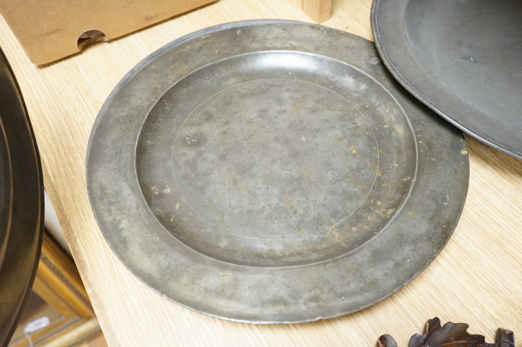 Three Pewter chargers, a large dish and a plate, c.1800, largest dish 42cm diameter (5)